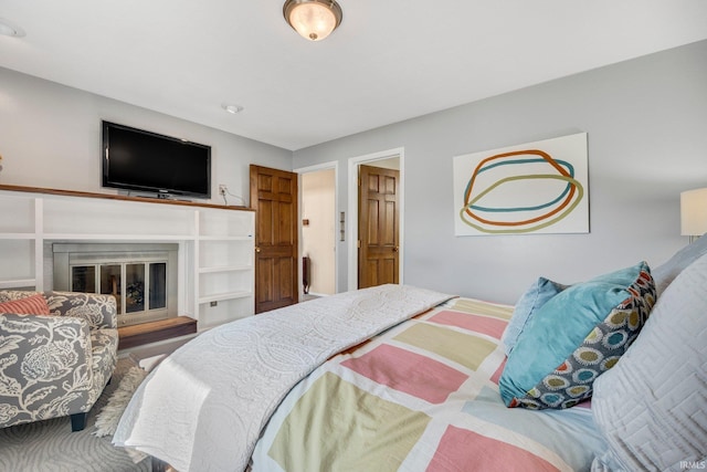 bedroom featuring a glass covered fireplace