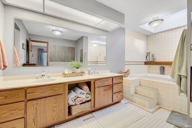 bathroom featuring tile patterned floors, double vanity, a sink, and a bath