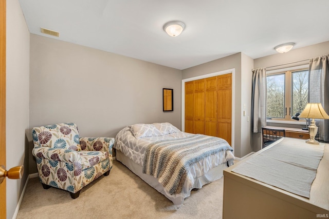 bedroom featuring light carpet, baseboards, visible vents, and a closet