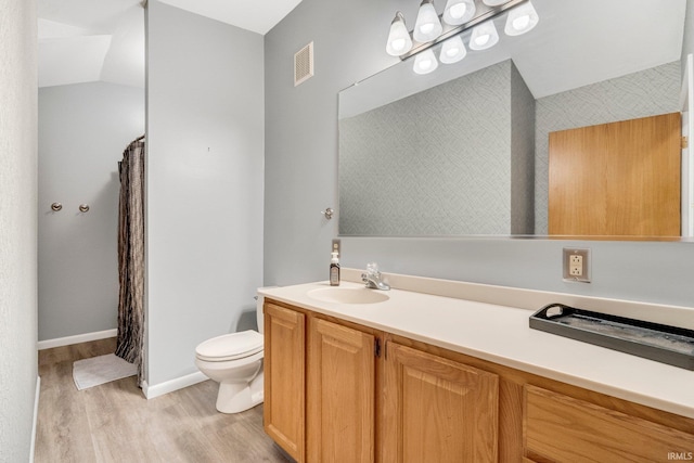 bathroom featuring curtained shower, visible vents, toilet, vanity, and wood finished floors