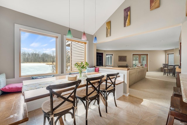 dining area with high vaulted ceiling