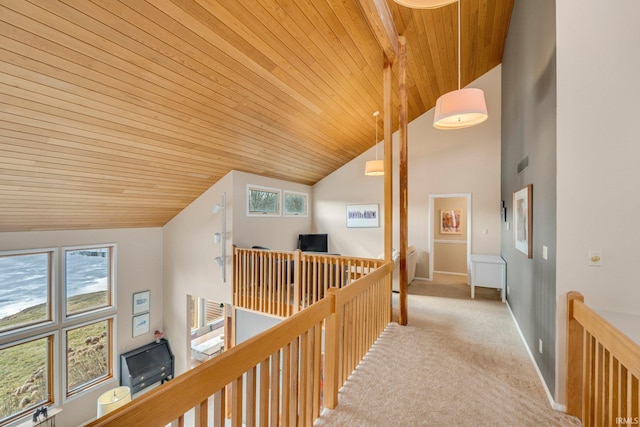 corridor with carpet, plenty of natural light, and an upstairs landing