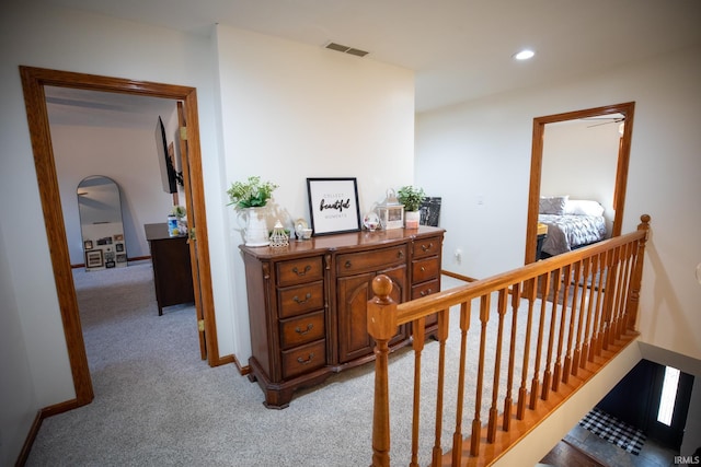 hallway featuring recessed lighting, visible vents, light carpet, an upstairs landing, and baseboards