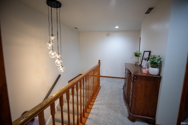 hall with baseboards, visible vents, an upstairs landing, carpet floors, and recessed lighting