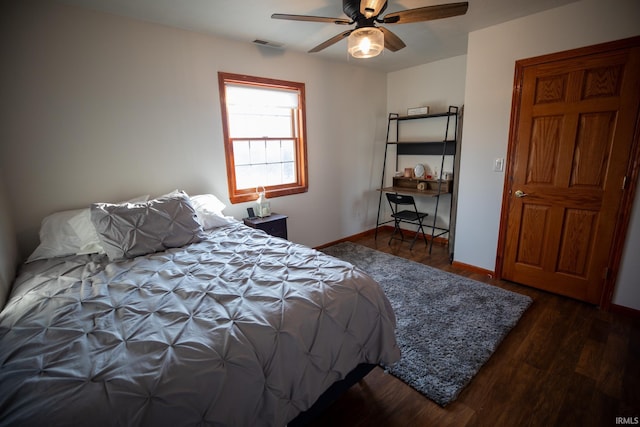 bedroom with a ceiling fan, baseboards, visible vents, and wood finished floors