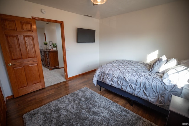 bedroom featuring visible vents, baseboards, and wood finished floors