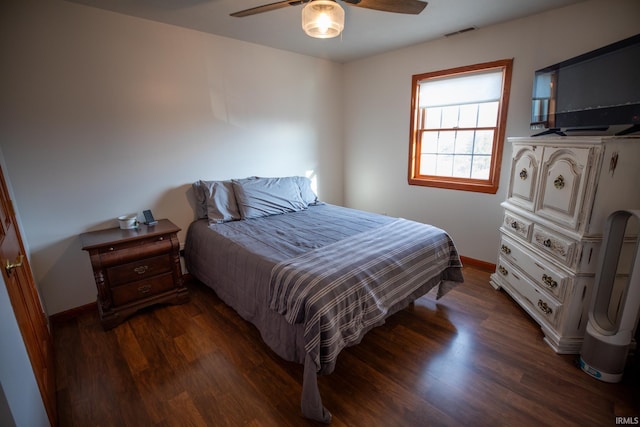 bedroom with baseboards, visible vents, dark wood finished floors, and a ceiling fan