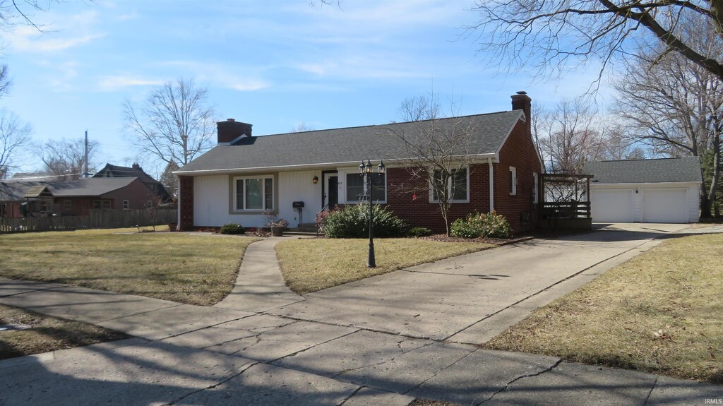 single story home with brick siding, an outdoor structure, a chimney, and a front lawn