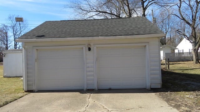 detached garage featuring fence