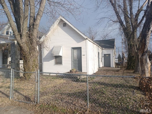 view of front of home with a fenced front yard and a gate