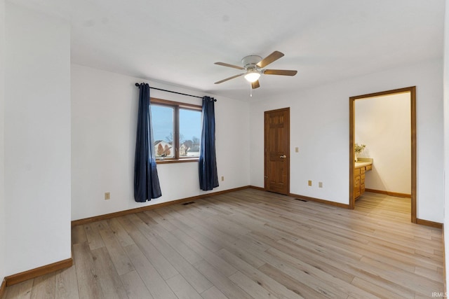 empty room featuring light wood-type flooring, ceiling fan, visible vents, and baseboards