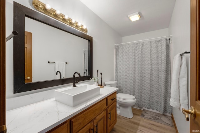 bathroom with vanity, wood finished floors, toilet, and a shower with curtain