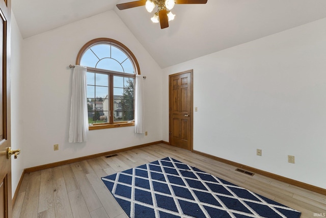 empty room featuring lofted ceiling, baseboards, visible vents, and light wood finished floors