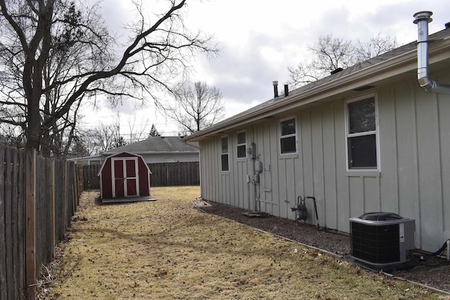 view of yard featuring a shed, an outdoor structure, a fenced backyard, and central air condition unit