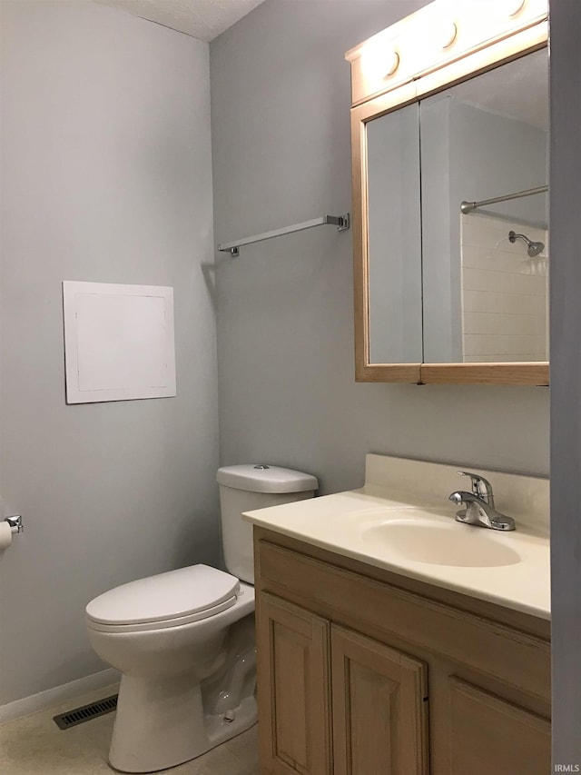 bathroom featuring baseboards, visible vents, toilet, tile patterned floors, and vanity