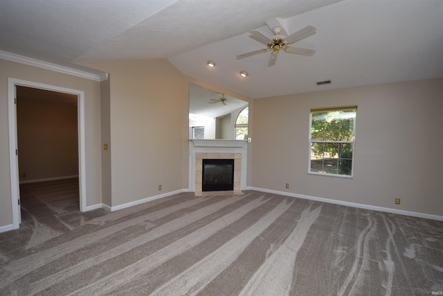 unfurnished living room featuring a tile fireplace, carpet flooring, vaulted ceiling, and visible vents