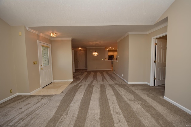 interior space featuring a textured ceiling, ornamental molding, and baseboards