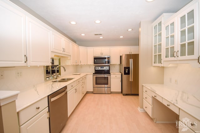 kitchen featuring visible vents, appliances with stainless steel finishes, light stone counters, white cabinetry, and a sink