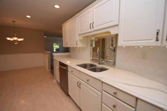 kitchen with a sink, white cabinets, hanging light fixtures, stainless steel dishwasher, and light wood-type flooring