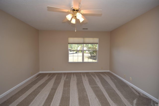 spare room with a ceiling fan, carpet flooring, visible vents, and baseboards