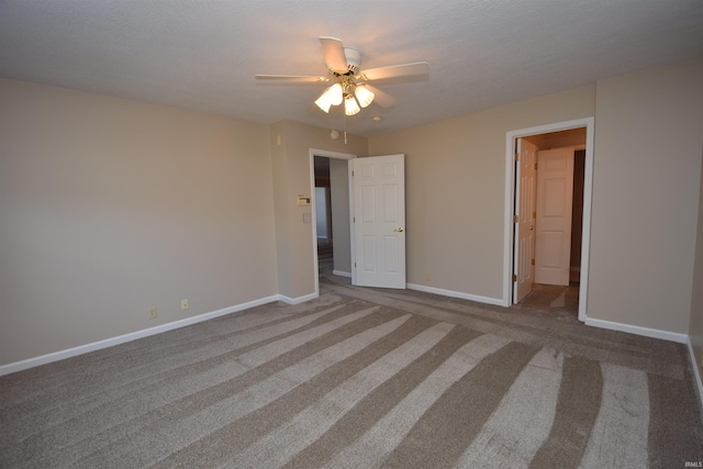 unfurnished bedroom featuring ceiling fan, a textured ceiling, baseboards, and carpet flooring