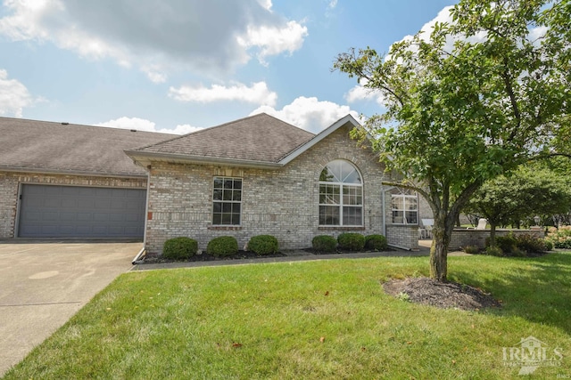 ranch-style house with driveway, an attached garage, a front lawn, and brick siding