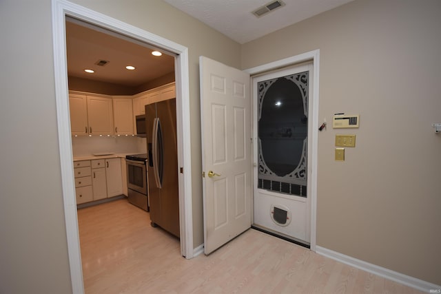 kitchen featuring stainless steel appliances, light wood-type flooring, light countertops, and visible vents