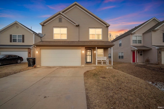 traditional home featuring a garage, covered porch, and driveway