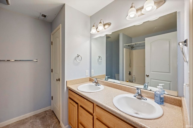 full bathroom featuring double vanity, toilet, a shower, and a sink