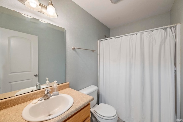 bathroom with curtained shower, vanity, and toilet