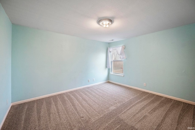 carpeted spare room featuring baseboards