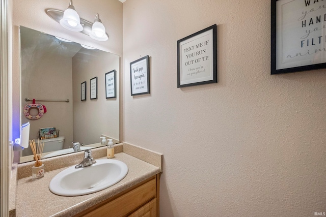 half bathroom with vanity and toilet