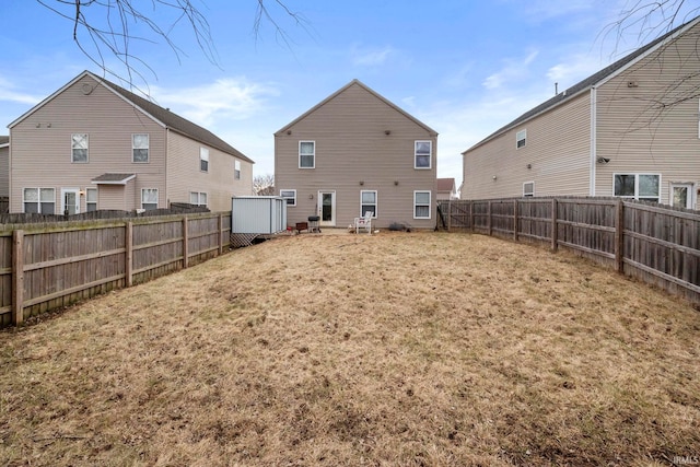 rear view of house with a fenced backyard and a yard