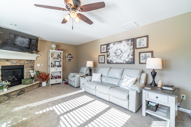 living area with a ceiling fan, carpet, visible vents, and a fireplace