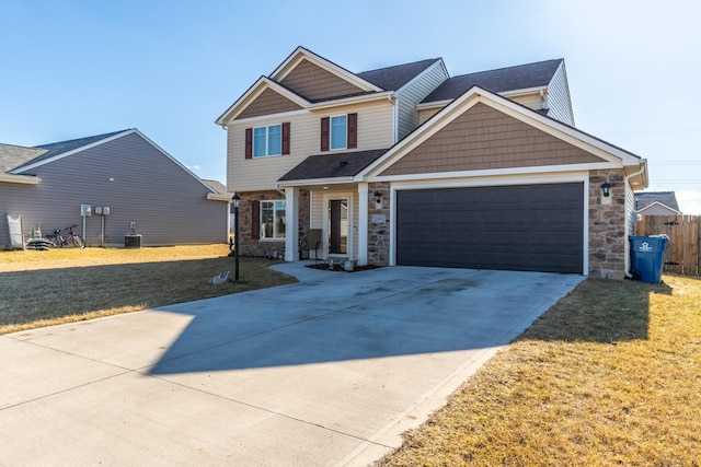 view of front of home with stone siding, an attached garage, driveway, and a front lawn