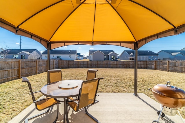 view of patio featuring a gazebo, outdoor dining space, grilling area, and a residential view