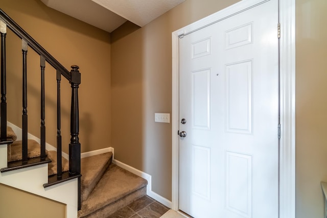 doorway featuring baseboards and stairs