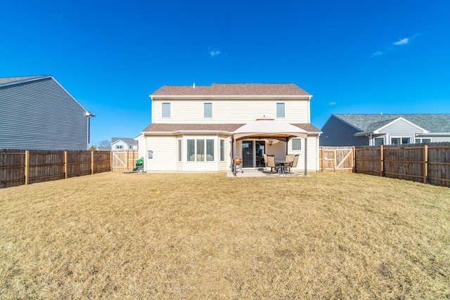 back of property featuring a fenced backyard, a lawn, and a patio