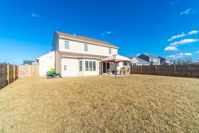 rear view of property with a patio, a lawn, a gazebo, and a fenced backyard