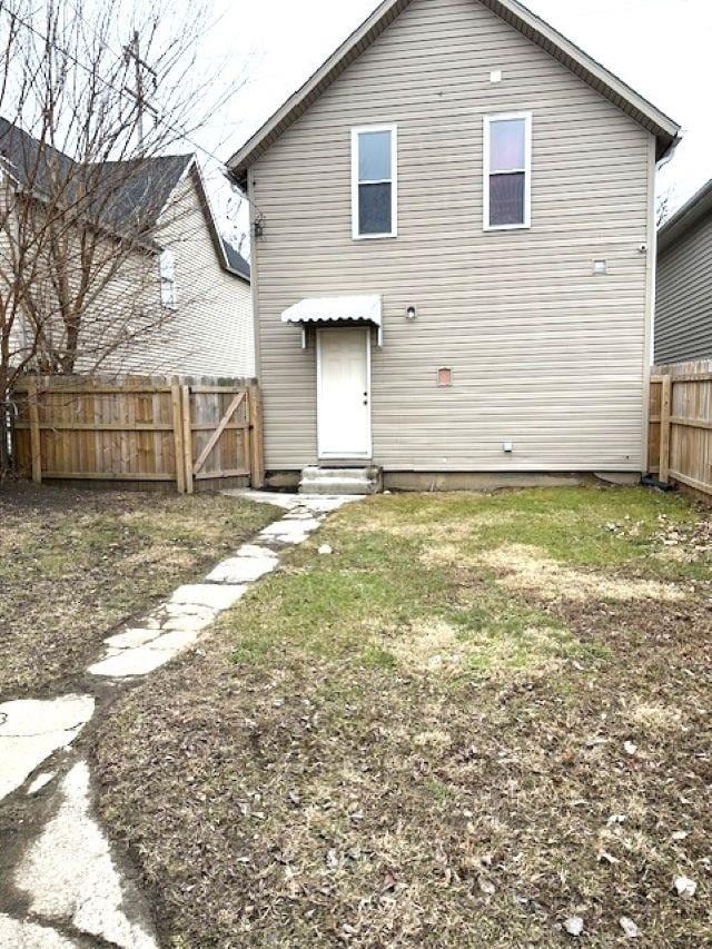 back of property featuring entry steps and fence