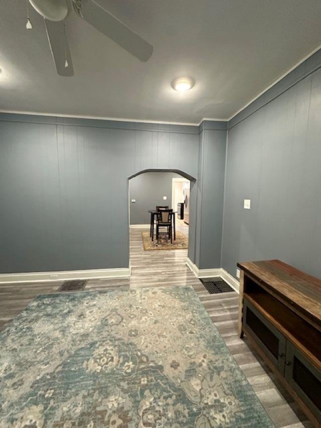 hallway featuring light wood finished floors and arched walkways