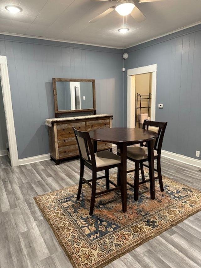 dining area with ceiling fan, crown molding, baseboards, and wood finished floors