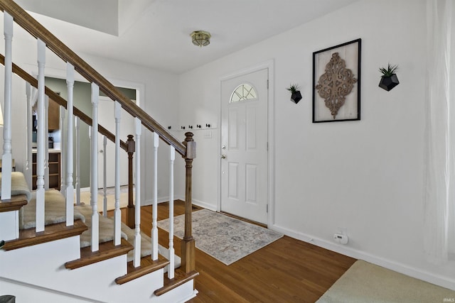 entryway with stairway, baseboards, and wood finished floors