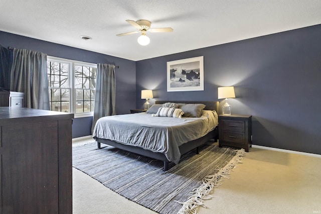 carpeted bedroom with a ceiling fan, visible vents, and baseboards