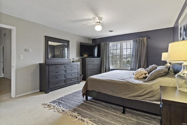 bedroom featuring light colored carpet, ceiling fan, and baseboards