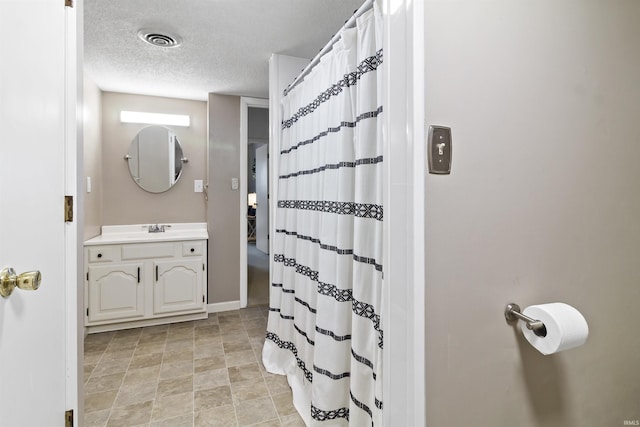 full bath with a textured ceiling, a shower with shower curtain, vanity, and visible vents