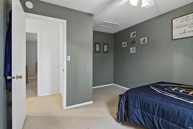 carpeted bedroom featuring attic access, baseboards, and ceiling fan