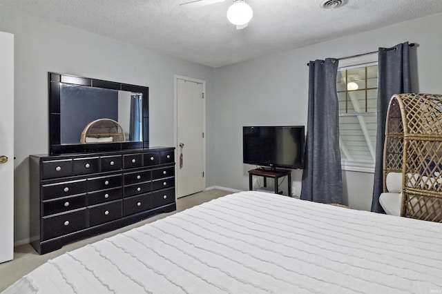 carpeted bedroom featuring baseboards, visible vents, and a textured ceiling