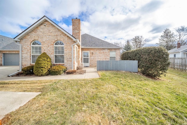 view of front of house with a front yard, a chimney, fence, and brick siding