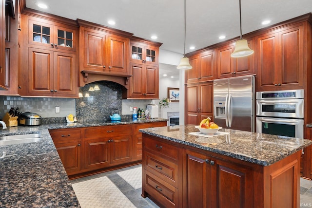 kitchen with stainless steel appliances, tasteful backsplash, a sink, and glass insert cabinets